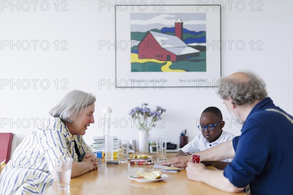 Temporary grandparents. Elderly couple volunteer to look after a boy from Africa for a few hours a week.