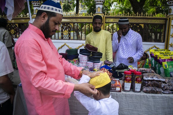 Indian Muslim father buys cap for his son before perform the second Friday prayer in the holy month of Ramadan at a Mosque in Guwahati