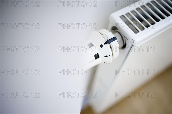 Symbol photo on the subject of increased heating costs. The thermostat of a heating system is set to the symbol snowflake