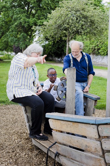 Temporary grandparents. Elderly couple volunteer to look after a boy from Africa for a few hours a week.