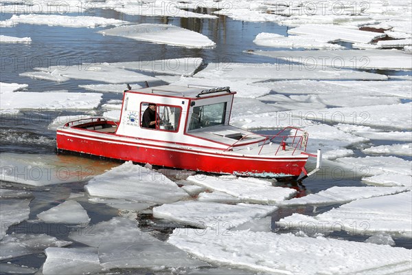 Small red boat between ice sheets