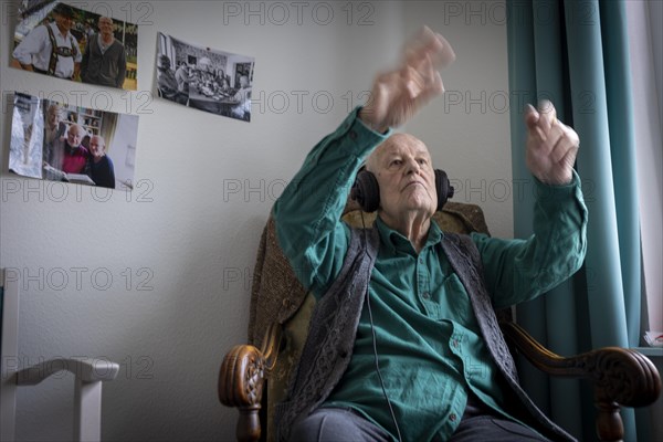 Old man in nursing home conducts to music