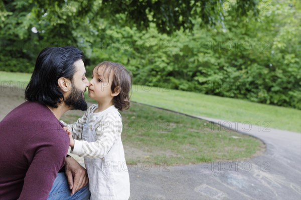 Father with child on a playground in the green