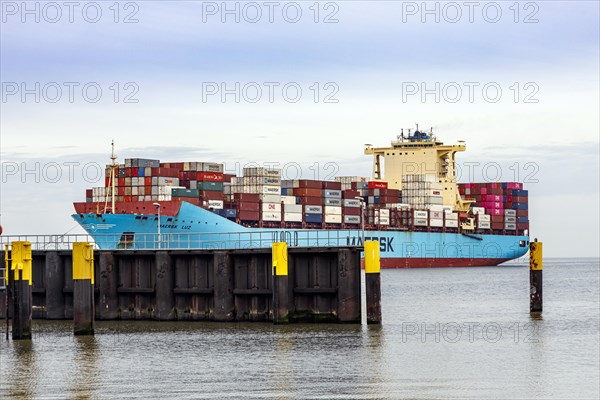 Tugboat guides the container ship Maersk Luz to the unloading berth at Ueberseehafen