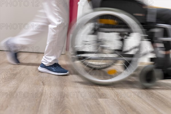 Geriatric nurse pushing a wheelchair in a nursing home