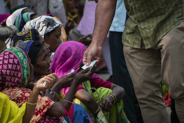 Indian Muslims person give money to needy people after perform the second Friday prayer in the holy month of Ramadan at a Mosque in Guwahati