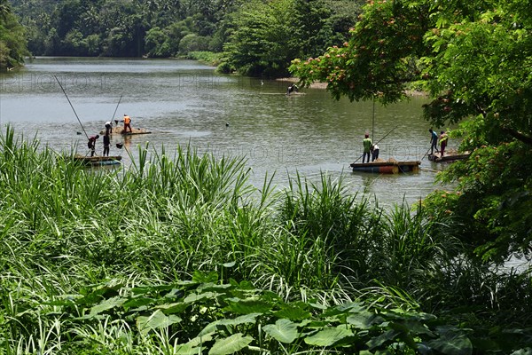 Workers scoop sand for building from the Mahaweli River