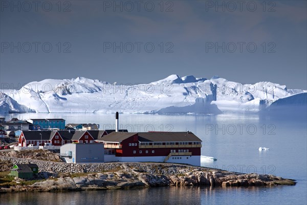 Icebergs and colourful houses in the town Ilulissat