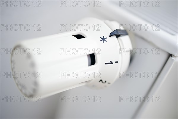 Symbol photo on the subject of increased heating costs. The thermostat of a heating system is set to the symbol snowflake