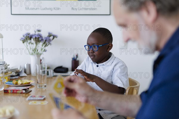 Temporary grandparents. Elderly couple volunteer to look after a boy from Africa for a few hours a week.