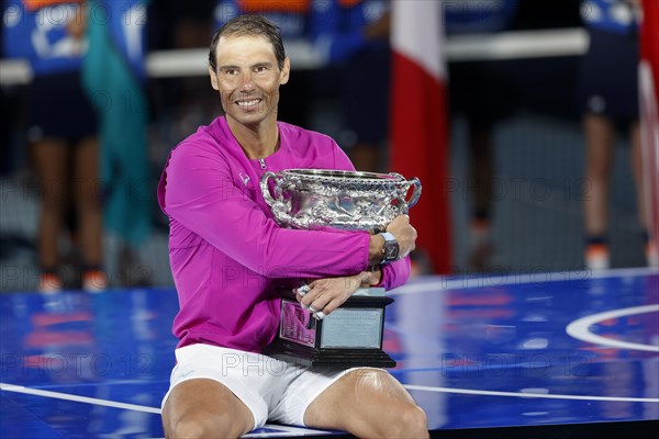 Spanish tennis player Rafael Nadal posing with the championship trophy after winning the mens singles final match of the Australian Open 2022