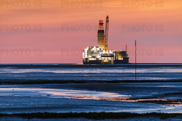 View from the Trischendamm to Germanys only drilling platform Mittelplate after sunset at low tide