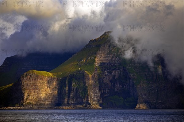 The Faroe Island of Kalsoy in the Atlantic Ocean with Sun and Clouds