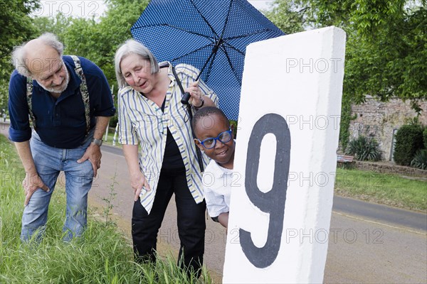 Temporary grandparents. Elderly couple volunteer to look after a boy from Africa for a few hours a week.