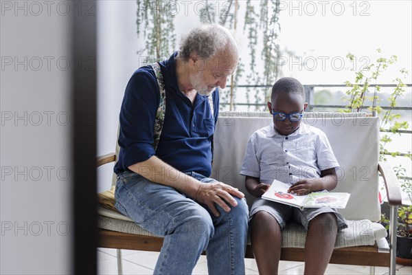 Temporary grandparents. Grandfather volunteers to look after a boy from Africa for a few hours a week.