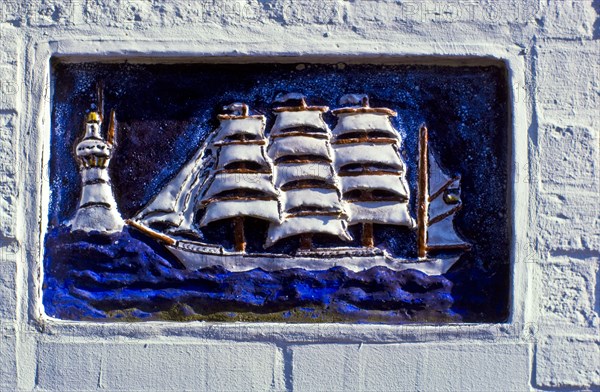 Relief panel of a sailing ship on a house wall on the island of Spiekeroog