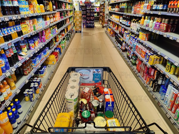 Shopping trolley being pushed through an aisle