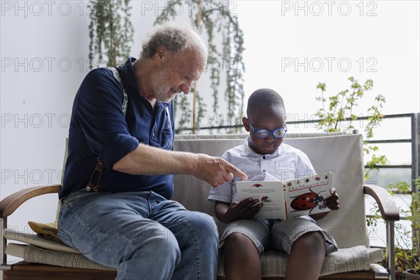 Temporary grandparents. Grandfather volunteers to look after a boy from Africa for a few hours a week.