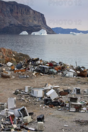 Rubbish at garbage dump and icebergs at the fishing village Uummannaq