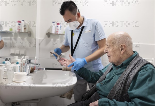 Caregiver and old man in a nursing home