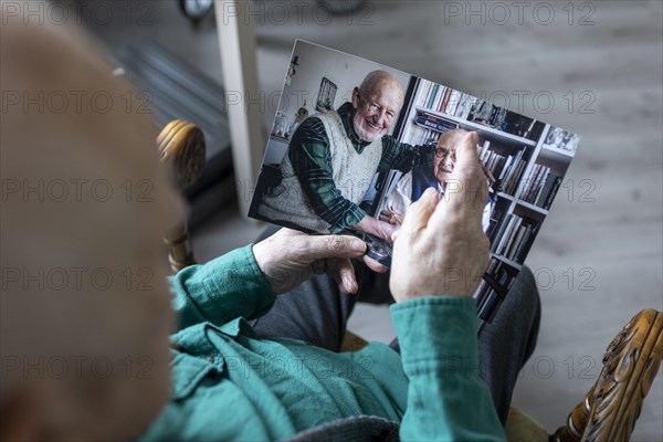 Old man with a photo of himself