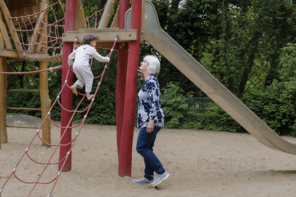 Volunteer. Temporary grandmother with a child in the playground.