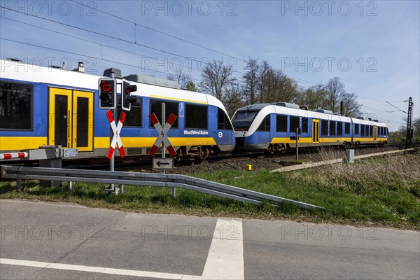 NordWestBahn passes through a level crossing with barriers