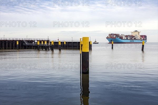 Tugboat guides the container ship Maersk Luz to the unloading berth at Ueberseehafen