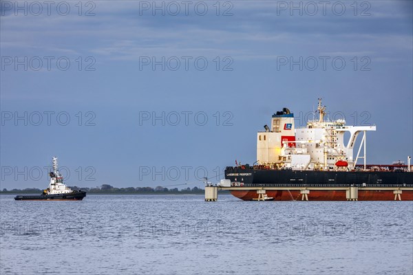 Tugboat at the crude oil tanker Landbridge Prosperity at the discharge bridge of the NWO in the Jade Bay