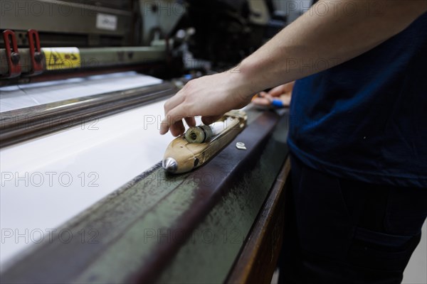 Inserting a spool of yarn into a shuttle in a weaving mill in the Allgaeu.