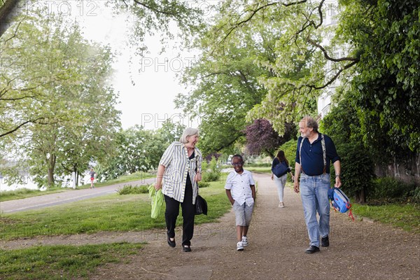 Temporary grandparents. Elderly couple volunteer to look after a boy from Africa for a few hours a week.