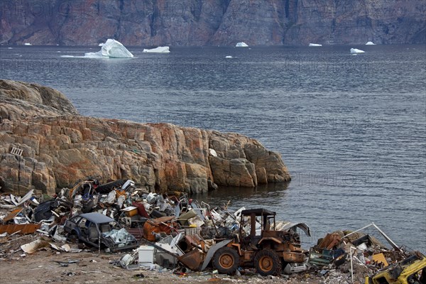 Rubbish at garbage dump and icebergs at the fishing village Uummannaq