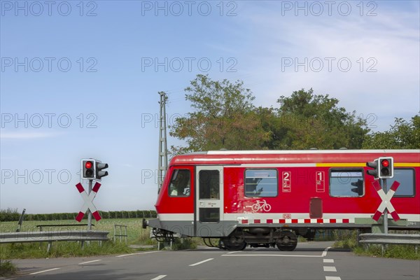 Passenger train passing a level crossing with barriers