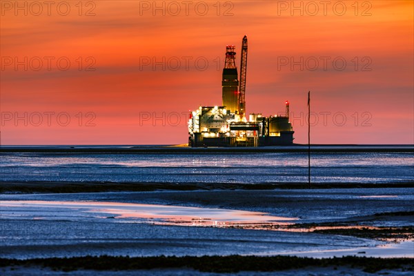 View from the Trischendamm to Germanys only drilling platform Mittelplate after sunset at low tide