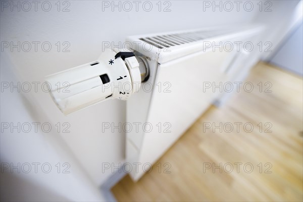 Symbol photo on the subject of increased heating costs. The thermostat of a heating system is set to the symbol snowflake