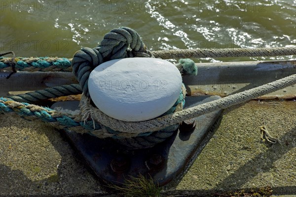 Bollard with cordage on a quay wall