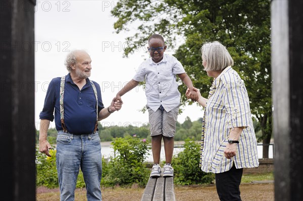 Grandparents on time. Grandparents with a boy on a playground.