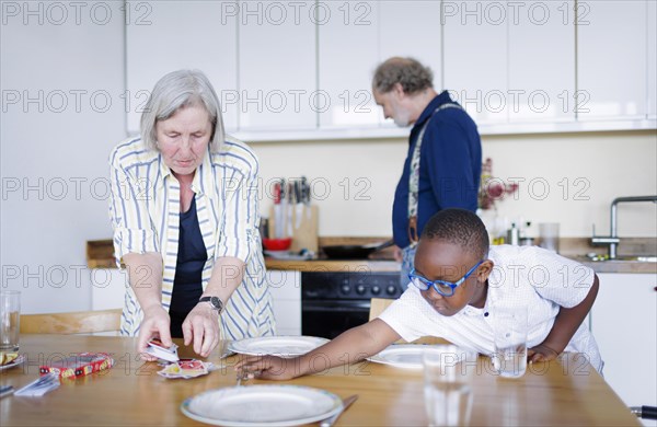 Temporary grandparents. Elderly couple volunteer to look after a boy from Africa for a few hours a week