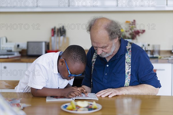 Temporary grandparents. Grandfather volunteers to look after a boy from Africa for a few hours a week.