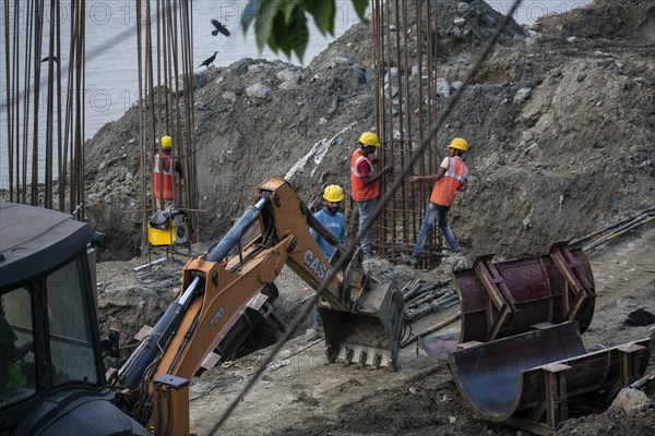 Construction workers busy build pillars of a bridge in the banks of Brahmaputra river on April 3