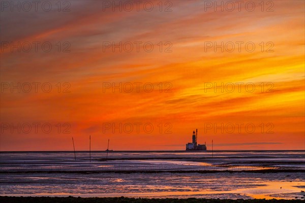 View from the Trischendamm to Germanys only drilling platform Mittelplate after sunset at low tide