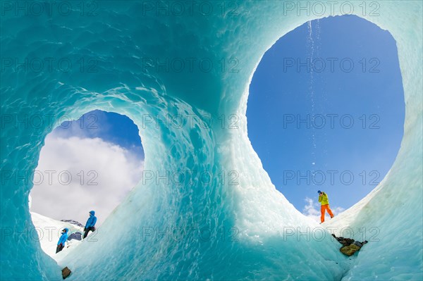 Hikers in front of an ice cave