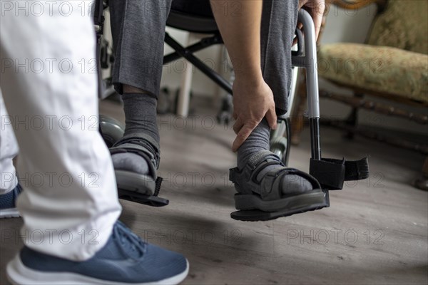 Carer helps old man stand up in a nursing home