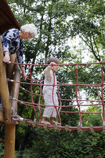 Volunteer. Temporary grandmother with a child in the playground.