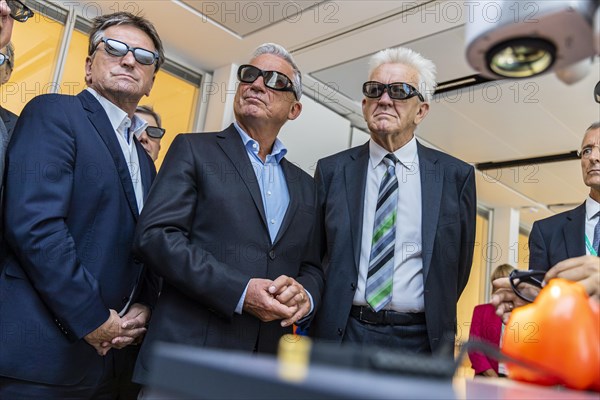 Three ministers wearing black 3D glasses. From right