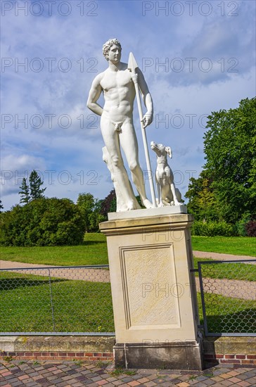 Nude stone male sculpture with lance and dog