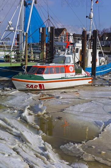 Sea rescue cruiser in the frozen harbour of Fedderwardersiel