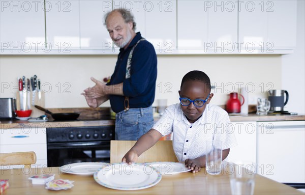 Temporary grandparents. Older man volunteers to look after a boy from Africa for a few hours a week.