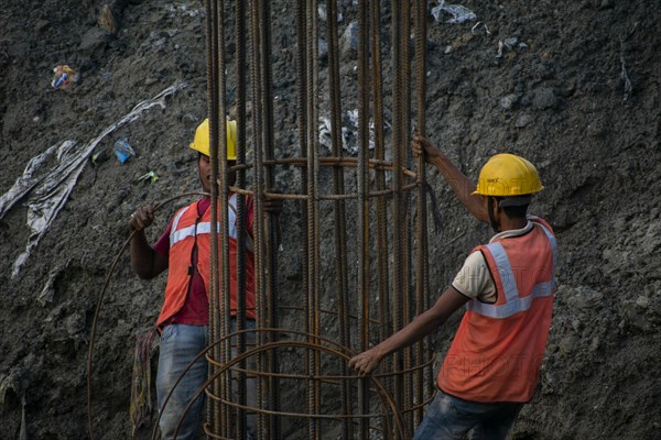 Construction workers busy build pillars of a bridge in the banks of Brahmaputra river on April 3