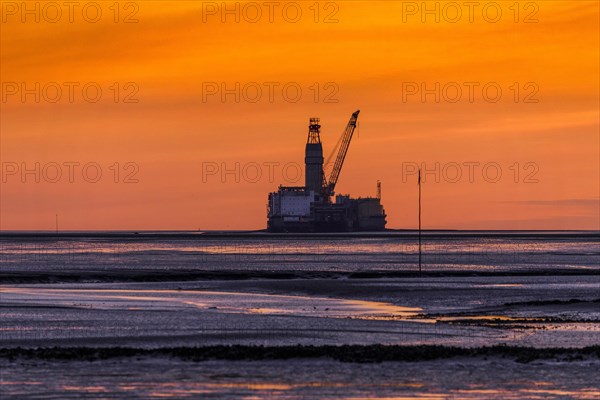 View from the Trischendamm to Germanys only drilling platform Mittelplate after sunset at low tide